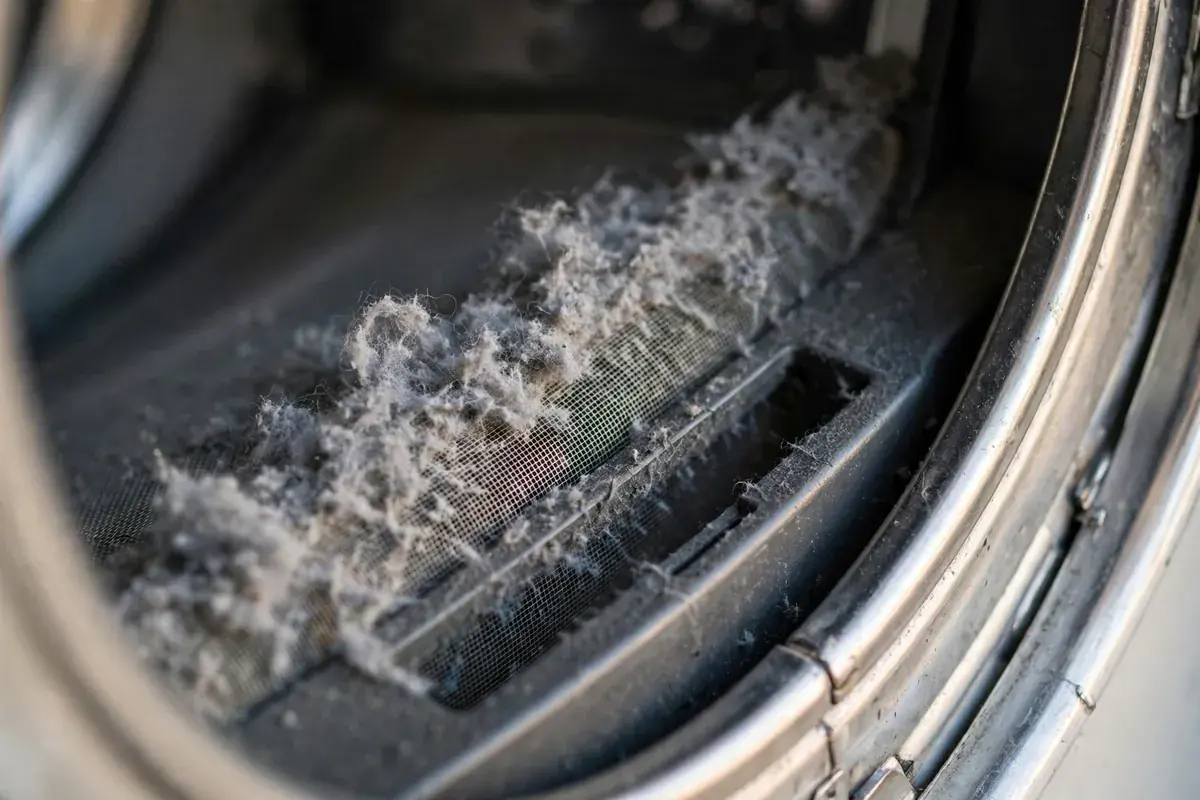 Lint screen slot of a dryer packed with grey lint